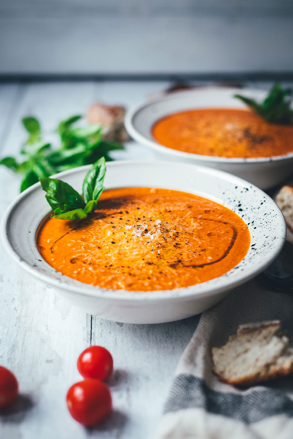 Rezept für cremige Tomatensuppe als blitzschnelle Rösttomatensuppe aus dem Ofen. Verfeinert mit Zwiebeln, Knoblauch, Parmesan und Basilikum. Fix auf dem Tisch und perfekt für die schnelle Feierabendküche im Spätsommer! | moeyskitchen.com