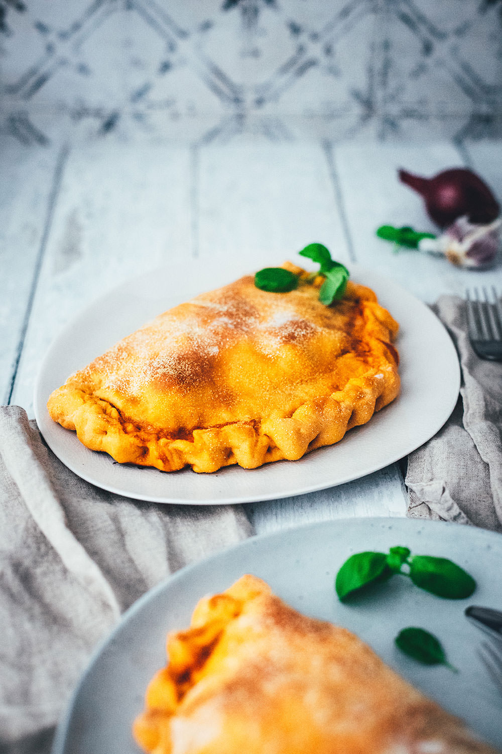 Rezept für knusprige Calzone – italienische Pizza, die als Pizzatasche gebacken wird. Mit leckerer Füllung aus Tomatensauce, Mozzarella, Schinken und Salami. Lässt sich super vorbereiten, einfrieren und frisch genießen. Ganz easy zu Hause selber machen und im normalen Ofen backen! | moeyskitchen.com
