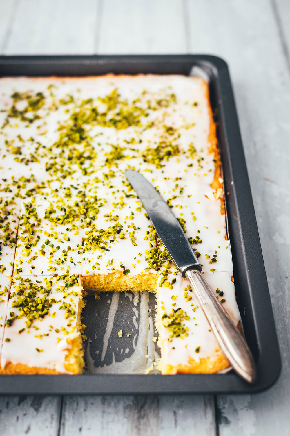 Der beste Zitronenkuchen – Rezept für super einfachen Zitronenkuchen vom Blech. Lockerer Rührteig verwandelt sich in einen genial saftigen und fluffigen Kuchen mit tollem Zitronenaroma. Ganz einfach zu backen und so lecker! | moeyskitchen.com