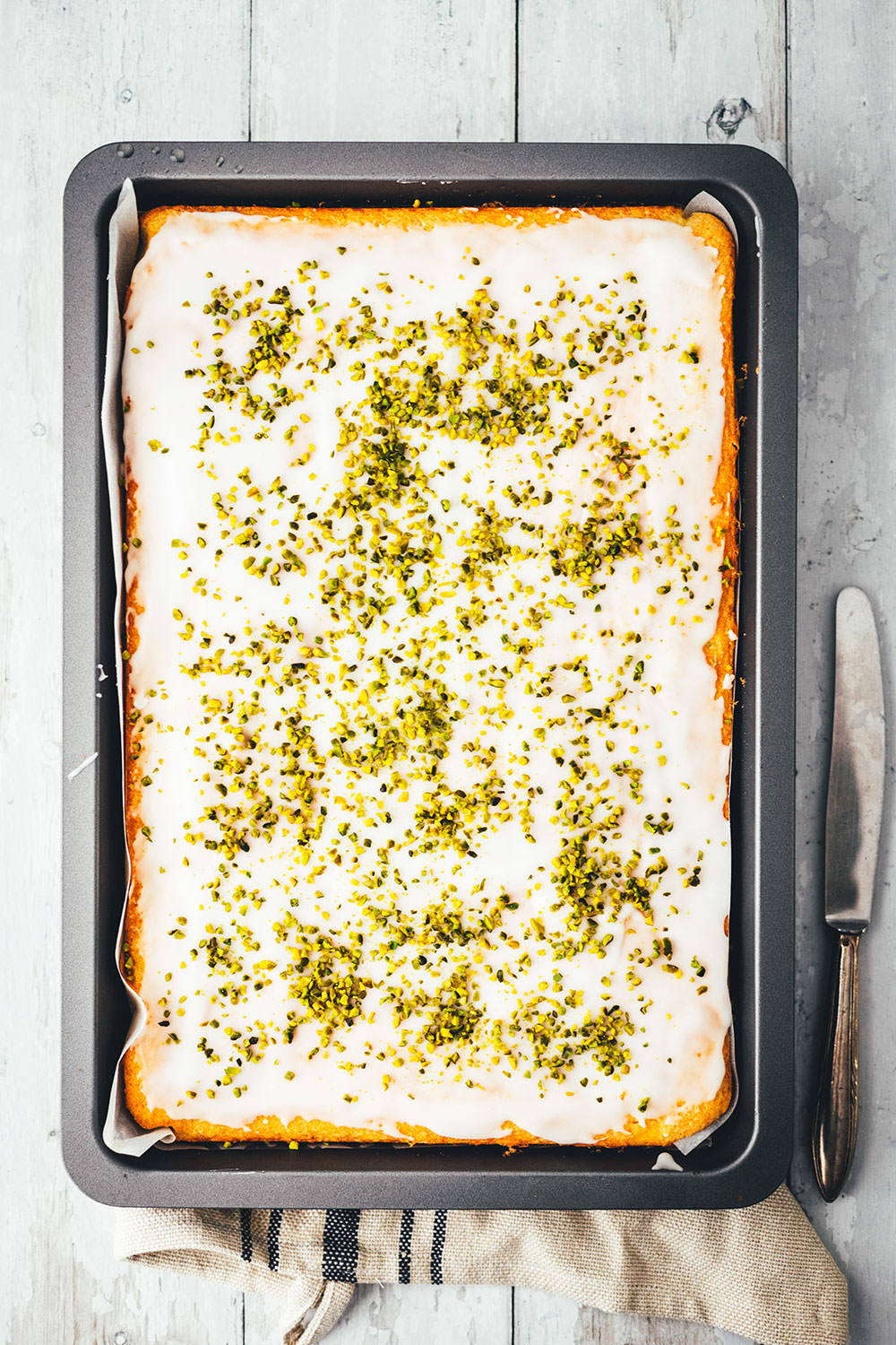 Der beste Zitronenkuchen – Rezept für super einfachen Zitronenkuchen vom Blech. Lockerer Rührteig verwandelt sich in einen genial saftigen und fluffigen Kuchen mit tollem Zitronenaroma. Ganz einfach zu backen und so lecker! | moeyskitchen.com