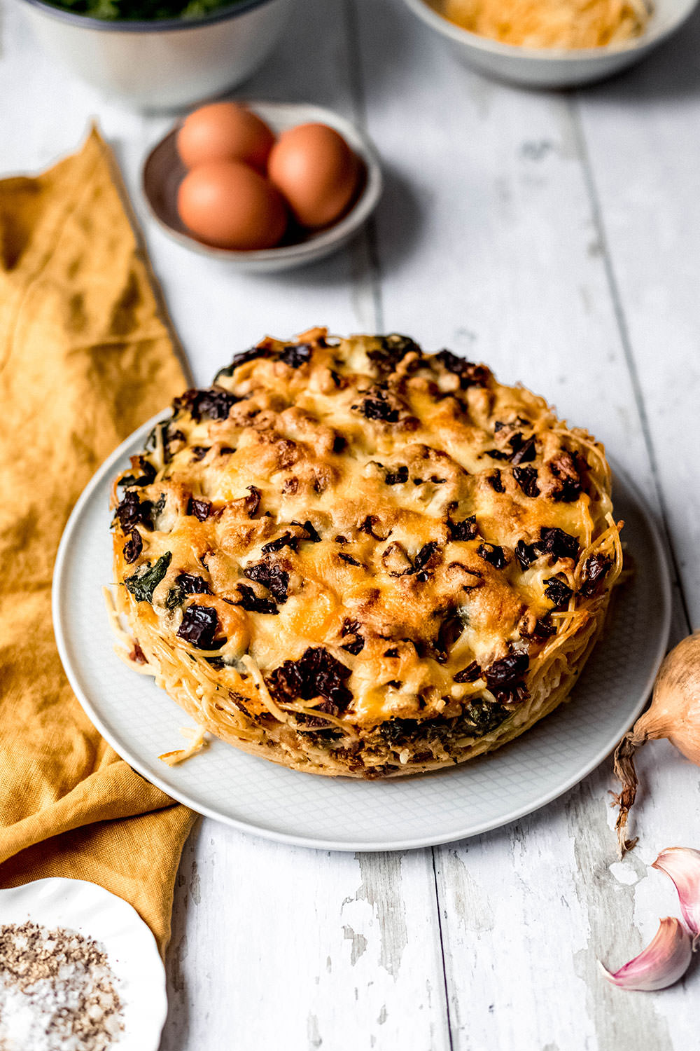 Nudelauflauf aus der Springform als runder "Kuchen" serviert und bereit zum Anschneiden.