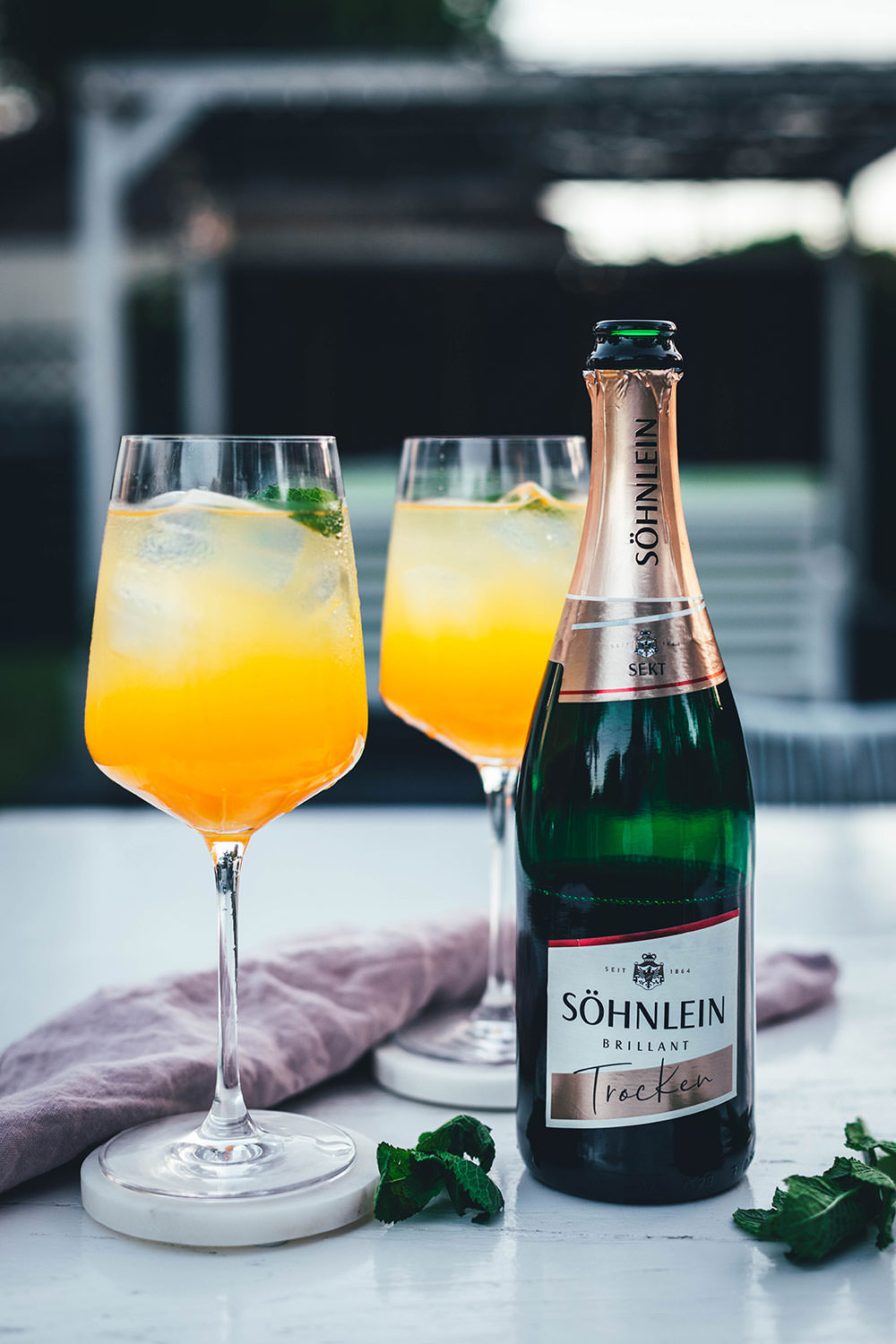 Rezept für Pfirsich-Maracuja-Spritz. Das ist ein leckerer Sektcocktail mit Pfirsichlikör und Maracuja-Nektar. Ganz einfach und ohne Bar-Equipment angerührt und ein toller Drink für den Spätsommer | moeyskitchen.com