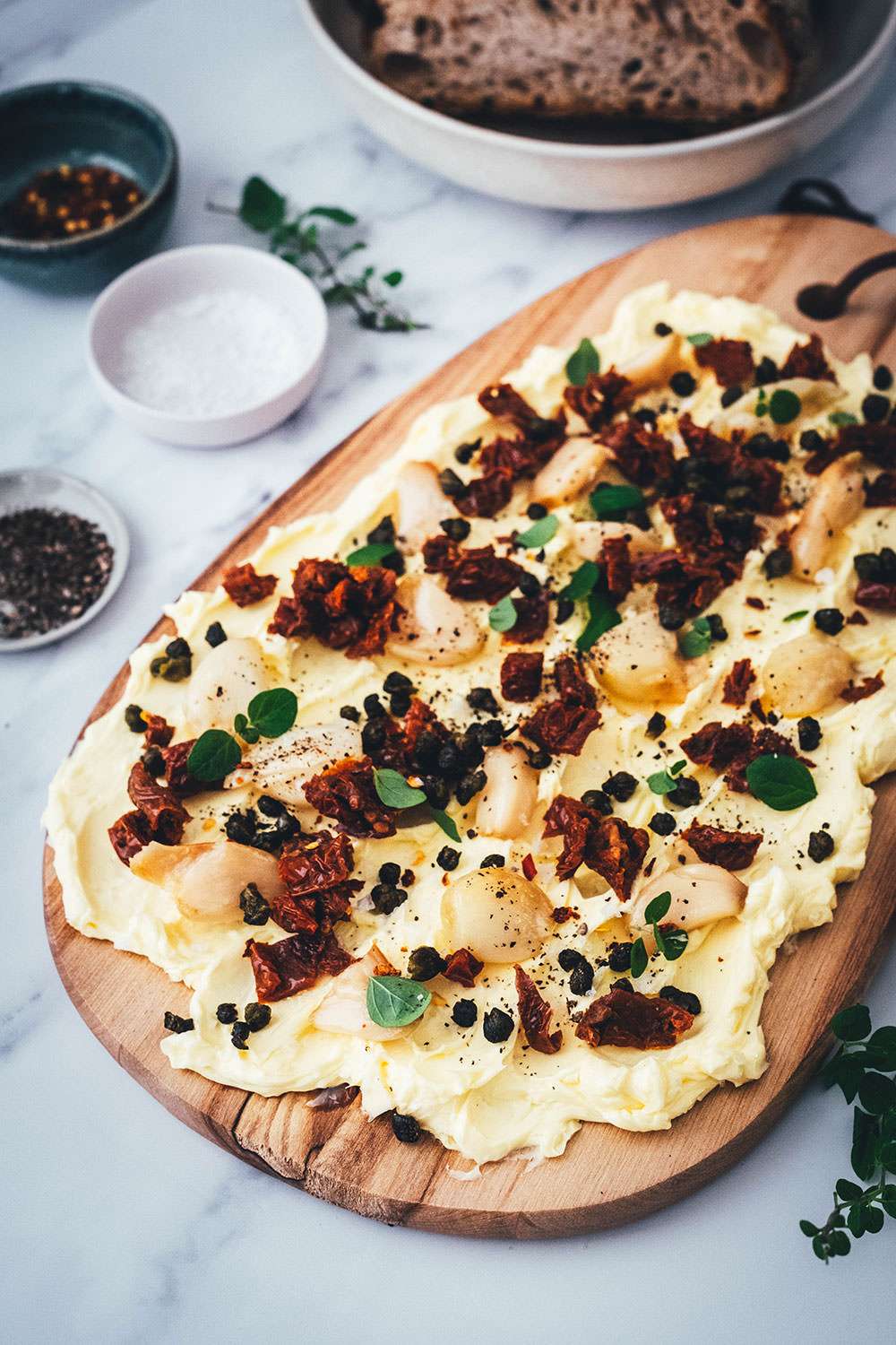 Rezept für ein Butter Board. Das Trend-Gericht von TikTok jetzt in meiner Version! Hier als herzhafte Variante mit geröstetem Knoblauch, getrockneten Tomaten und frittierten Kapern. Alle Infos zu Butter Boards und ob sie den Hype wert sind, hier im Blog! | moeyskitchen.com