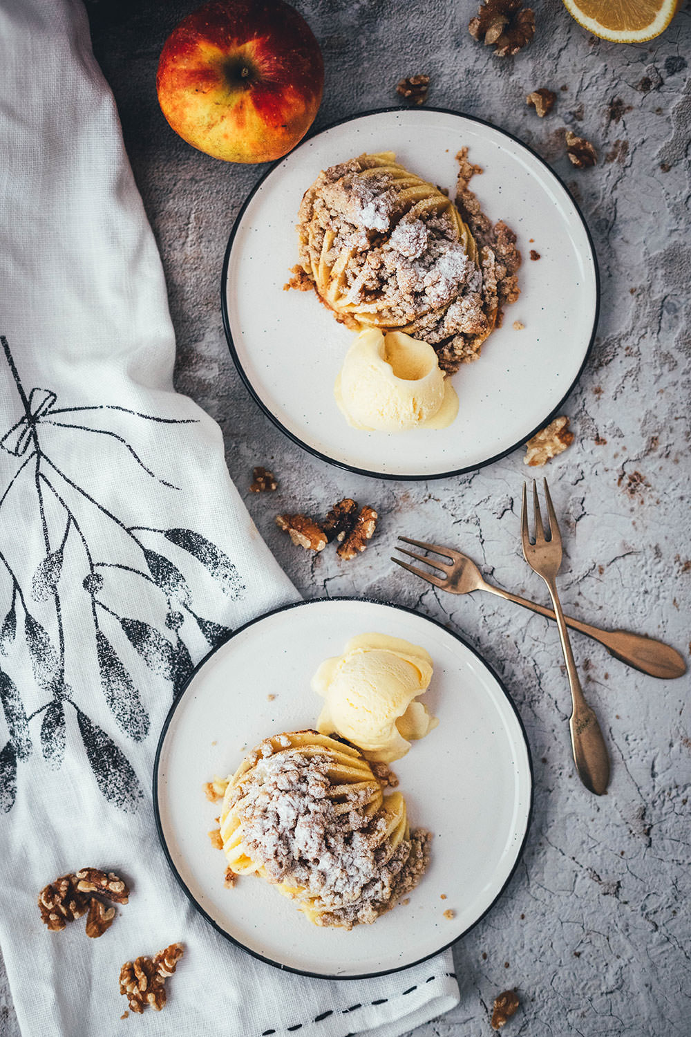Wunderbare Rezeptidee für gebackene Äpfel mit Streuseln. Süßer Bratapfel trifft auf klassischen Apple Crumble oder Apple Crisp – heraus kommt mein Hasselback Bratapfel. Dafür werden halbierte Äpfel fächerförmig eingeschnitten, im Ofen gebacken und dann mit leckeren Streuseln bestreut. In diesen stecken gehackte Walnüsse und Haferflocken, das macht sie lecker und knusprig! | moeyskitchen.com
