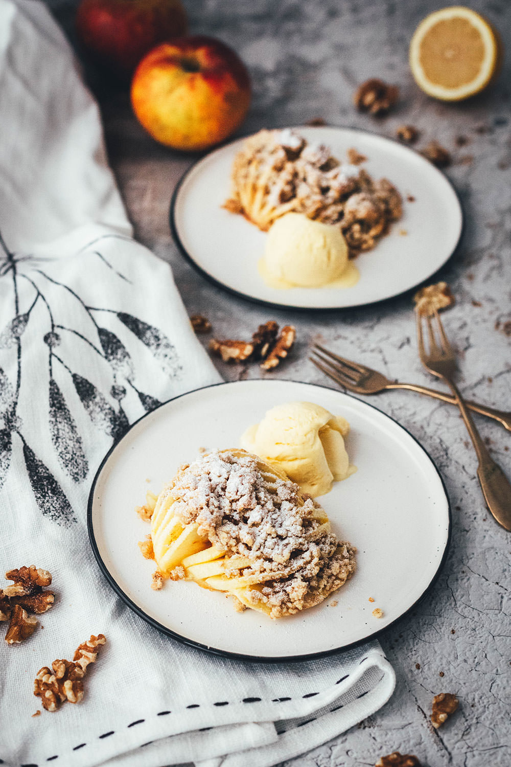 Wunderbare Rezeptidee für gebackene Äpfel mit Streuseln. Süßer Bratapfel trifft auf klassischen Apple Crumble oder Apple Crisp – heraus kommt mein Hasselback Bratapfel. Dafür werden halbierte Äpfel fächerförmig eingeschnitten, im Ofen gebacken und dann mit leckeren Streuseln bestreut. In diesen stecken gehackte Walnüsse und Haferflocken, das macht sie lecker und knusprig! | moeyskitchen.com