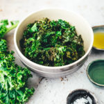 Eine Schüssel voll mit grünen, knusprigen Chips aus Grünkohl, verfeinert mit Olivenöl und Gewürzen | moeyskitchen.com