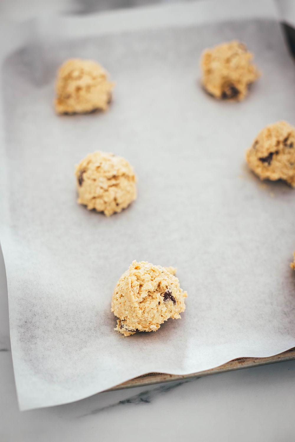Hier verrate ich mein Rezept für die besten Haferflocken Cookies! In den USA kennt man vor allem Oatmeal Raisin Cookies. Ich backe meine Haferflocken-Kekse hier allerdings ohne Rosinen und stattdessen mit Schokostückchen. Das Ergebnis sind wunderbar softe Chocolate Chip Oatmeal Cookies. Weiche, schokoladige, aber nicht zu süße Haferkekse. Die Zubereitung ist wirklich sehr einfach, dazu ist die Besonderheit, dass diese Kekse ganz ohne Mehl auskommen. | moeyskitchen.com