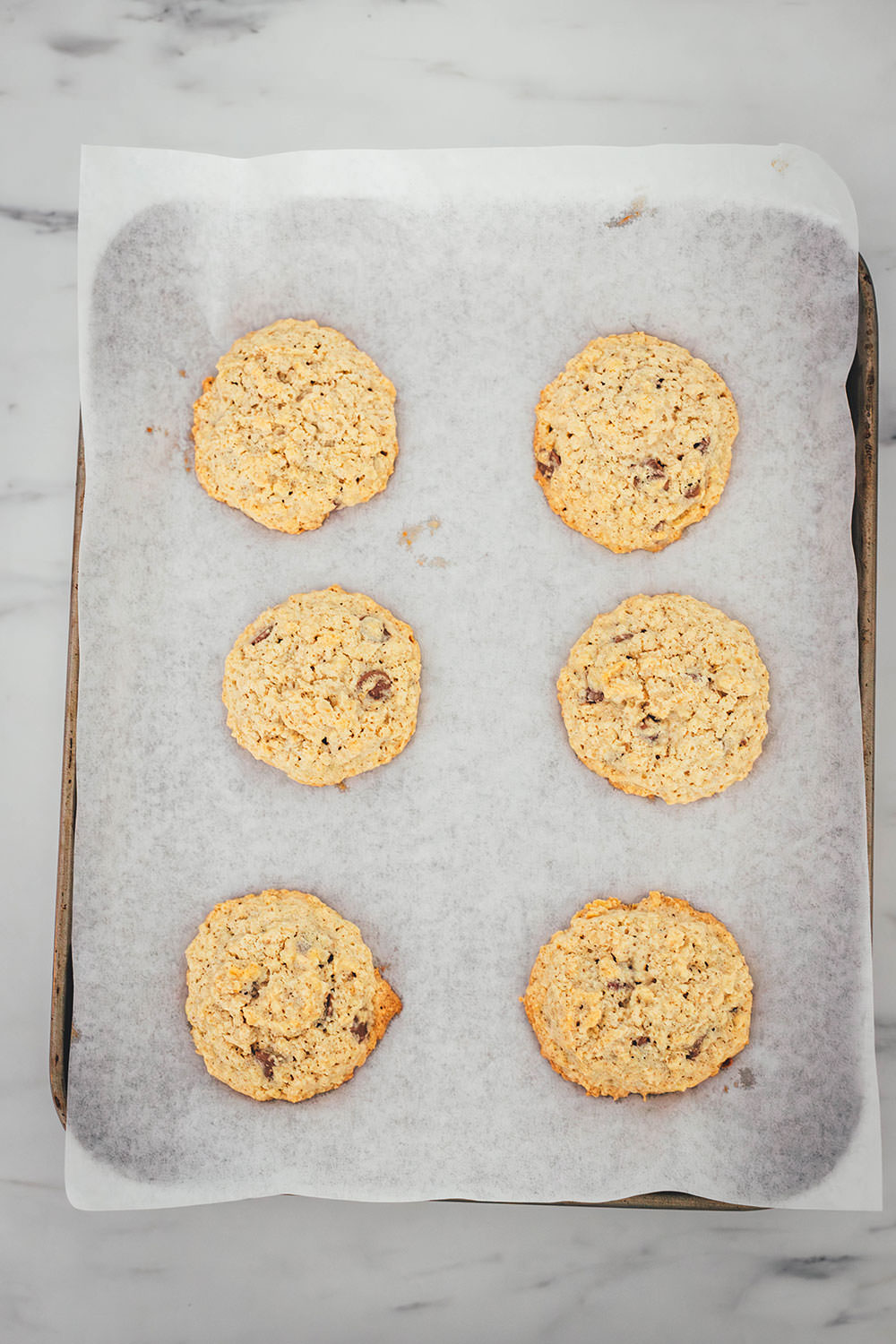 Hier verrate ich mein Rezept für die besten Haferflocken Cookies! In den USA kennt man vor allem Oatmeal Raisin Cookies. Ich backe meine Haferflocken-Kekse hier allerdings ohne Rosinen und stattdessen mit Schokostückchen. Das Ergebnis sind wunderbar softe Chocolate Chip Oatmeal Cookies. Weiche, schokoladige, aber nicht zu süße Haferkekse. Die Zubereitung ist wirklich sehr einfach, dazu ist die Besonderheit, dass diese Kekse ganz ohne Mehl auskommen. | moeyskitchen.com