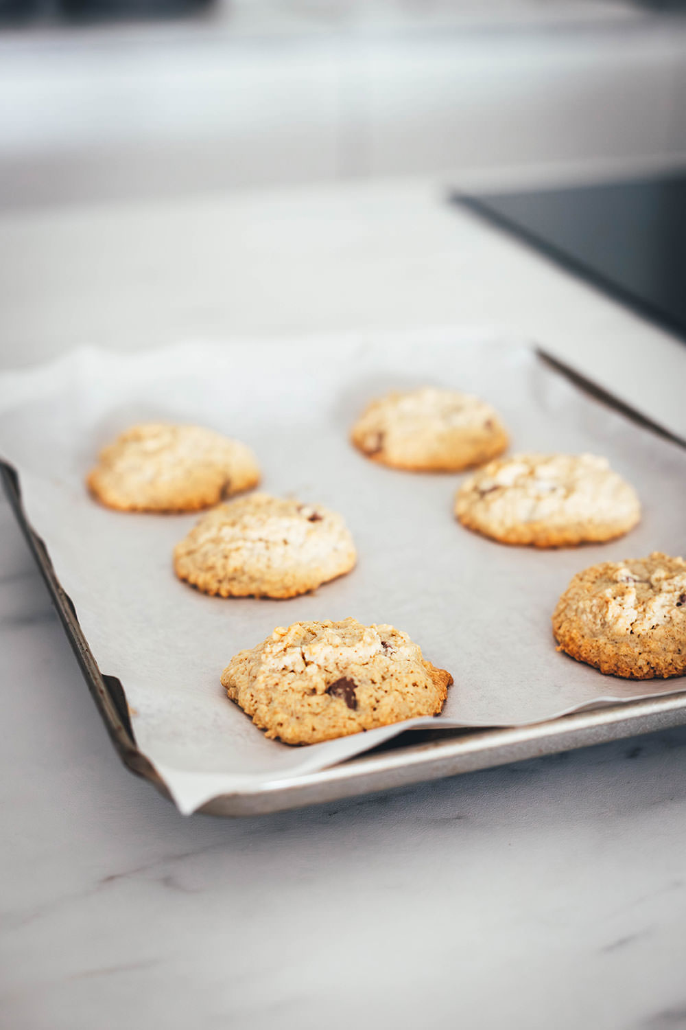 Hier verrate ich mein Rezept für die besten Haferflocken Cookies! In den USA kennt man vor allem Oatmeal Raisin Cookies. Ich backe meine Haferflocken-Kekse hier allerdings ohne Rosinen und stattdessen mit Schokostückchen. Das Ergebnis sind wunderbar softe Chocolate Chip Oatmeal Cookies. Weiche, schokoladige, aber nicht zu süße Haferkekse. Die Zubereitung ist wirklich sehr einfach, dazu ist die Besonderheit, dass diese Kekse ganz ohne Mehl auskommen. | moeyskitchen.com