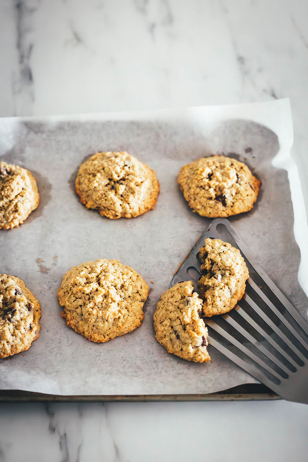 Hier verrate ich mein Rezept für die besten Haferflocken Cookies! In den USA kennt man vor allem Oatmeal Raisin Cookies. Ich backe meine Haferflocken-Kekse hier allerdings ohne Rosinen und stattdessen mit Schokostückchen. Das Ergebnis sind wunderbar softe Chocolate Chip Oatmeal Cookies. Weiche, schokoladige, aber nicht zu süße Haferkekse. Die Zubereitung ist wirklich sehr einfach, dazu ist die Besonderheit, dass diese Kekse ganz ohne Mehl auskommen. | moeyskitchen.com