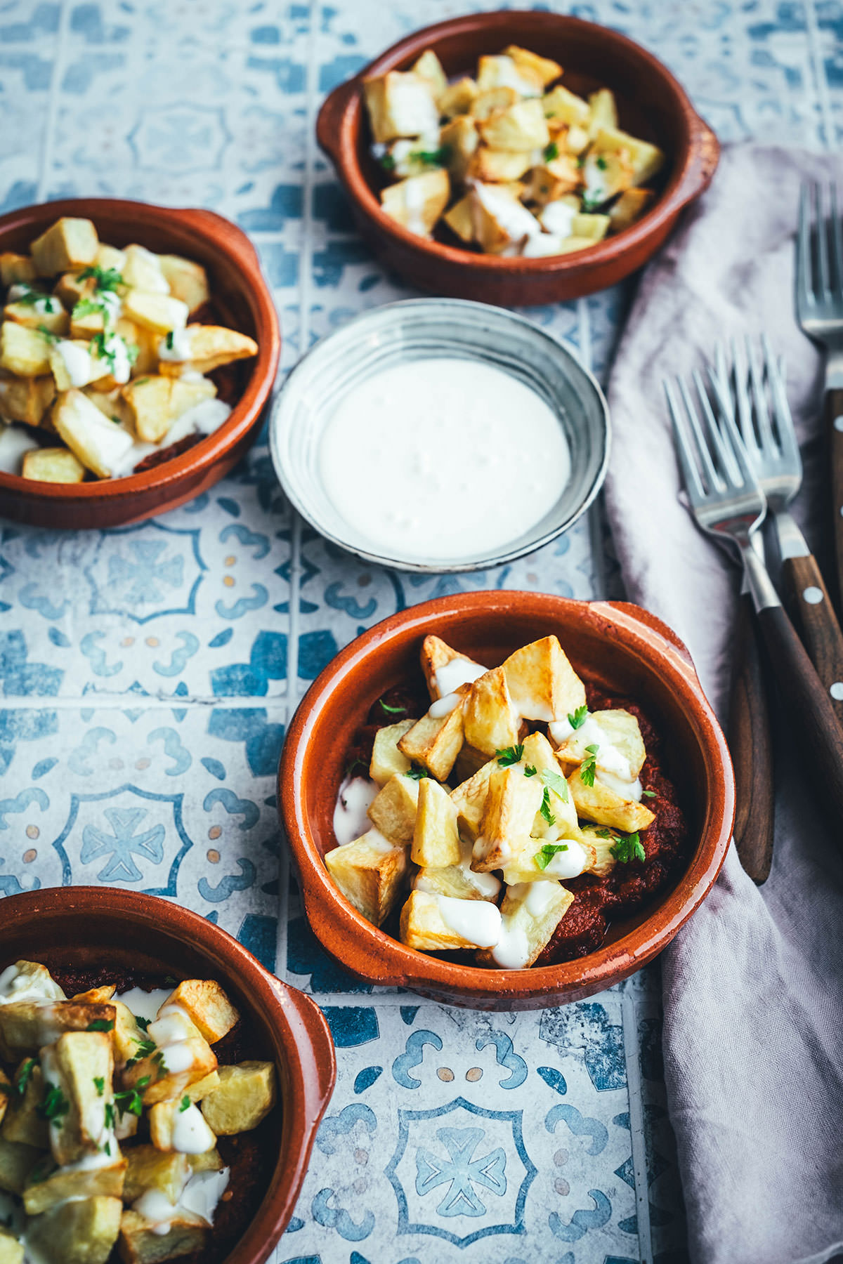 Wenn ich an spanische Tapas denke, denke ich zuerst an Patatas Bravas! Knusprig frittierte Kartoffeln mit einer scharfen roten Sauce und einer würzigen weißen Sauce. Schon als Kind habe ich sie geliebt. Jetzt habe ich mir den Spanien-Urlaub nach Hause geholt und bereite meine Patatas Bravas einfach im Air Fryer zu. Das geht super schnell und unkompliziert! So hat man in kürzester Zeit die perfekte Urlaubserinnerung auf dem Tisch stehen. Hier gibt es das köstliche Rezept für Kartoffelwürfel mit scharfer Tomatensauce (Salsa brava) und einer schnellen Knoblauchmayonnaise (Aioli)! | moeyskitchen.com