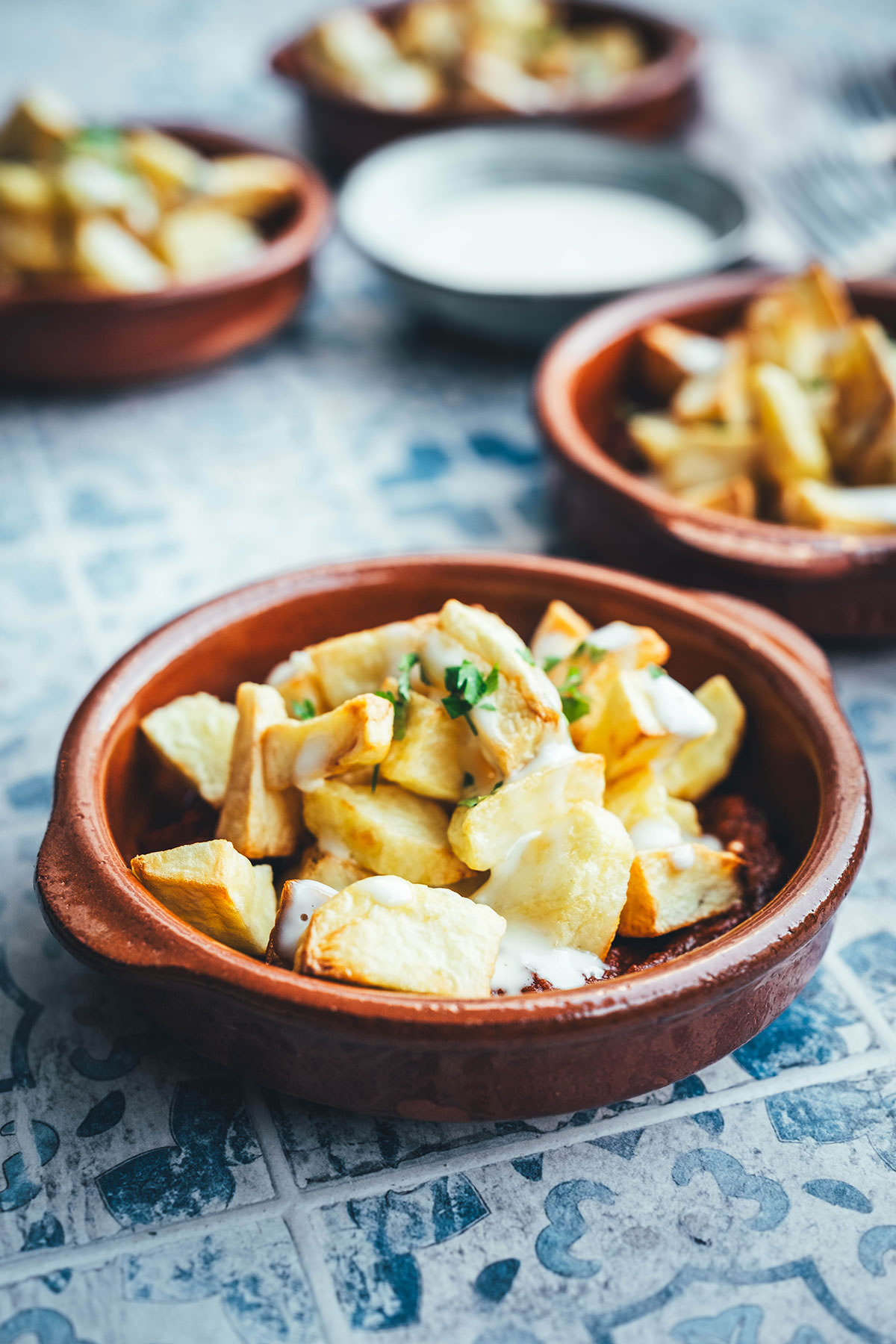 Wenn ich an spanische Tapas denke, denke ich zuerst an Patatas Bravas! Knusprig frittierte Kartoffeln mit einer scharfen roten Sauce und einer würzigen weißen Sauce. Schon als Kind habe ich sie geliebt. Jetzt habe ich mir den Spanien-Urlaub nach Hause geholt und bereite meine Patatas Bravas einfach im Air Fryer zu. Das geht super schnell und unkompliziert! So hat man in kürzester Zeit die perfekte Urlaubserinnerung auf dem Tisch stehen. Hier gibt es das köstliche Rezept für Kartoffelwürfel mit scharfer Tomatensauce (Salsa brava) und einer schnellen Knoblauchmayonnaise (Aioli)! | moeyskitchen.com