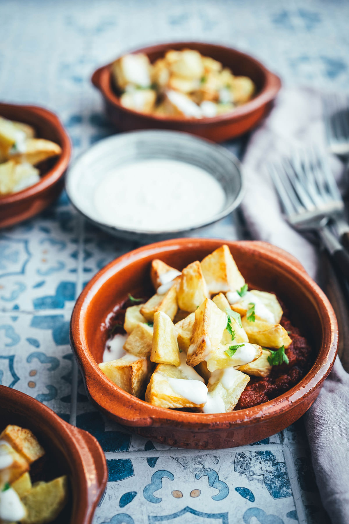 Wenn ich an spanische Tapas denke, denke ich zuerst an Patatas Bravas! Knusprig frittierte Kartoffeln mit einer scharfen roten Sauce und einer würzigen weißen Sauce. Schon als Kind habe ich sie geliebt. Jetzt habe ich mir den Spanien-Urlaub nach Hause geholt und bereite meine Patatas Bravas einfach im Air Fryer zu. Das geht super schnell und unkompliziert! So hat man in kürzester Zeit die perfekte Urlaubserinnerung auf dem Tisch stehen. Hier gibt es das köstliche Rezept für Kartoffelwürfel mit scharfer Tomatensauce (Salsa brava) und einer schnellen Knoblauchmayonnaise (Aioli)! | moeyskitchen.com