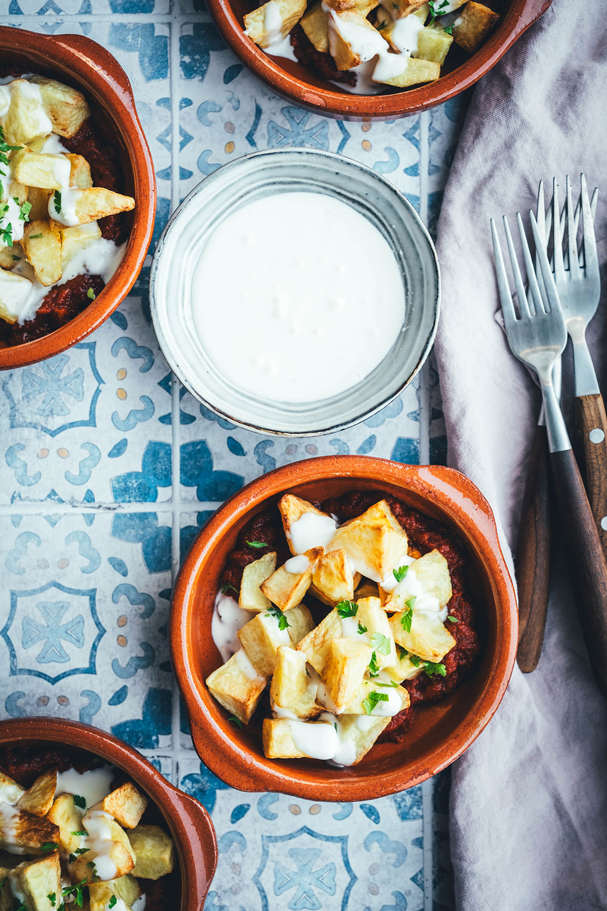 Wenn ich an spanische Tapas denke, denke ich zuerst an Patatas Bravas! Knusprig frittierte Kartoffeln mit einer scharfen roten Sauce und einer würzigen weißen Sauce. Schon als Kind habe ich sie geliebt. Jetzt habe ich mir den Spanien-Urlaub nach Hause geholt und bereite meine Patatas Bravas einfach im Air Fryer zu. Das geht super schnell und unkompliziert! So hat man in kürzester Zeit die perfekte Urlaubserinnerung auf dem Tisch stehen. Hier gibt es das köstliche Rezept für Kartoffelwürfel mit scharfer Tomatensauce (Salsa brava) und einer schnellen Knoblauchmayonnaise (Aioli)! | moeyskitchen.com