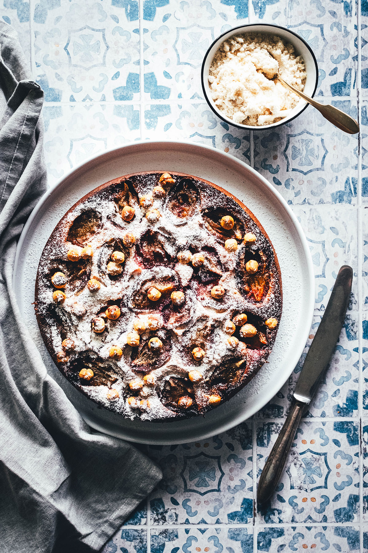Rezept für einen wunderbaren Spätsommer-Kuchen: Mein italienischer Pflaumenkuchen ist blitzschnell zusammengerührt. Durch Ricotta und Eier wird der Kuchen extrem saftig. Geröstete Haselnusskerne sorgen für eine knackige Komponente und werden außerdem mit Puderzucker vermixt nach dem Backen über den Kuchen gestreut. Eine spannende Alternative zu klassischem Zwetschgendatschi oder Pflaumenkuchen mit Streuseln! | moeyskitchen.com
