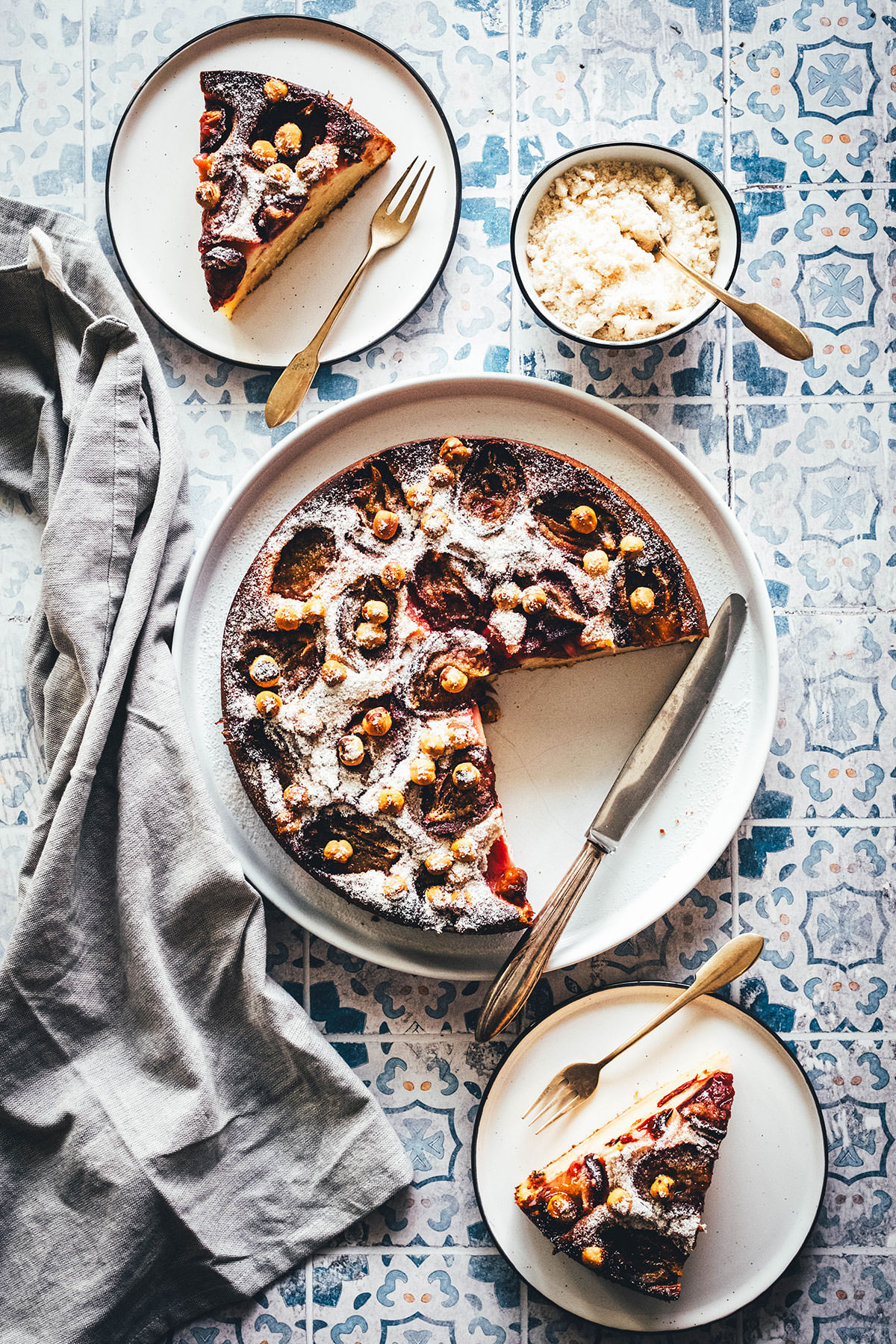 Rezept für einen wunderbaren Spätsommer-Kuchen: Mein italienischer Pflaumenkuchen ist blitzschnell zusammengerührt. Durch Ricotta und Eier wird der Kuchen extrem saftig. Geröstete Haselnusskerne sorgen für eine knackige Komponente und werden außerdem mit Puderzucker vermixt nach dem Backen über den Kuchen gestreut. Eine spannende Alternative zu klassischem Zwetschgendatschi oder Pflaumenkuchen mit Streuseln! | moeyskitchen.com