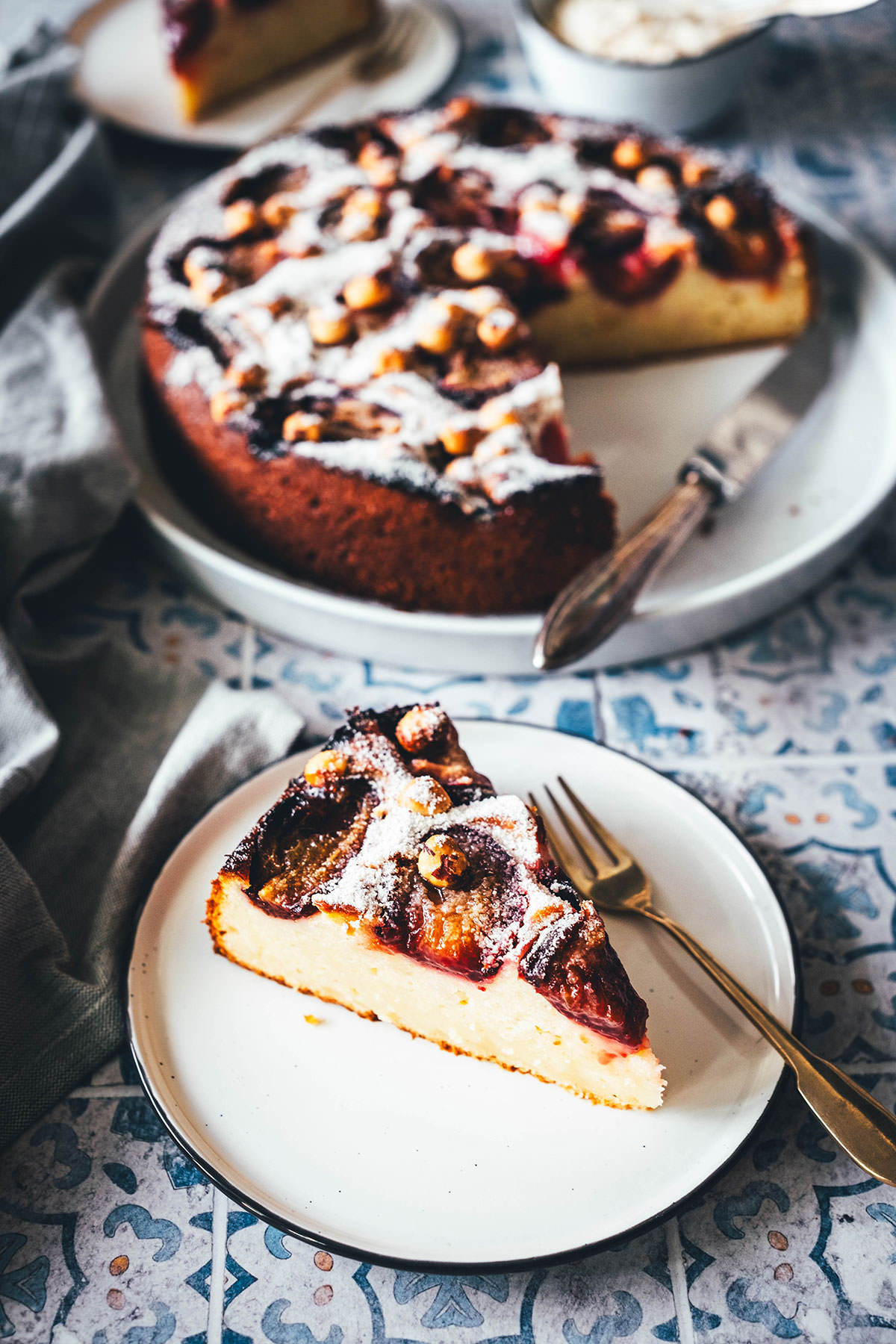 Rezept für einen wunderbaren Spätsommer-Kuchen: Mein italienischer Pflaumenkuchen ist blitzschnell zusammengerührt. Durch Ricotta und Eier wird der Kuchen extrem saftig. Geröstete Haselnusskerne sorgen für eine knackige Komponente und werden außerdem mit Puderzucker vermixt nach dem Backen über den Kuchen gestreut. Eine spannende Alternative zu klassischem Zwetschgendatschi oder Pflaumenkuchen mit Streuseln! | moeyskitchen.com