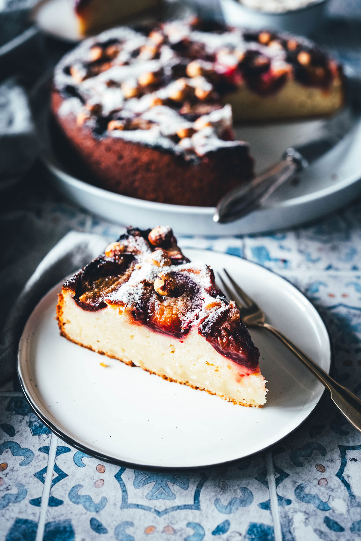 Rezept für einen wunderbaren Spätsommer-Kuchen: Mein italienischer Pflaumenkuchen ist blitzschnell zusammengerührt. Durch Ricotta und Eier wird der Kuchen extrem saftig. Geröstete Haselnusskerne sorgen für eine knackige Komponente und werden außerdem mit Puderzucker vermixt nach dem Backen über den Kuchen gestreut. Eine spannende Alternative zu klassischem Zwetschgendatschi oder Pflaumenkuchen mit Streuseln! | moeyskitchen.com