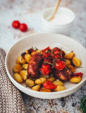 Rezept für One Pan Gnocchi – alles von einem Blech! Blitzschnell zubereitet für die sommerliche Feierabendküche. Gnocchi-Traybake mit Salsiccia, Paprika und Tomaten, serviert mit Knoblauch-Schmand. | moeyskitchen.com