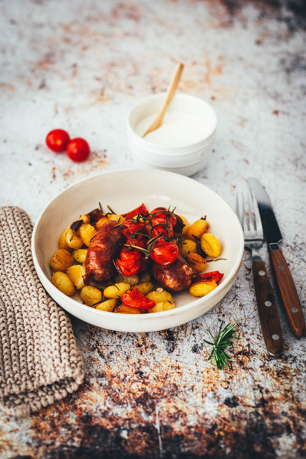 Rezept für One Pan Gnocchi – alles von einem Blech! Blitzschnell zubereitet für die sommerliche Feierabendküche. Gnocchi-Traybake mit Salsiccia, Paprika und Tomaten, serviert mit Knoblauch-Schmand. | moeyskitchen.com