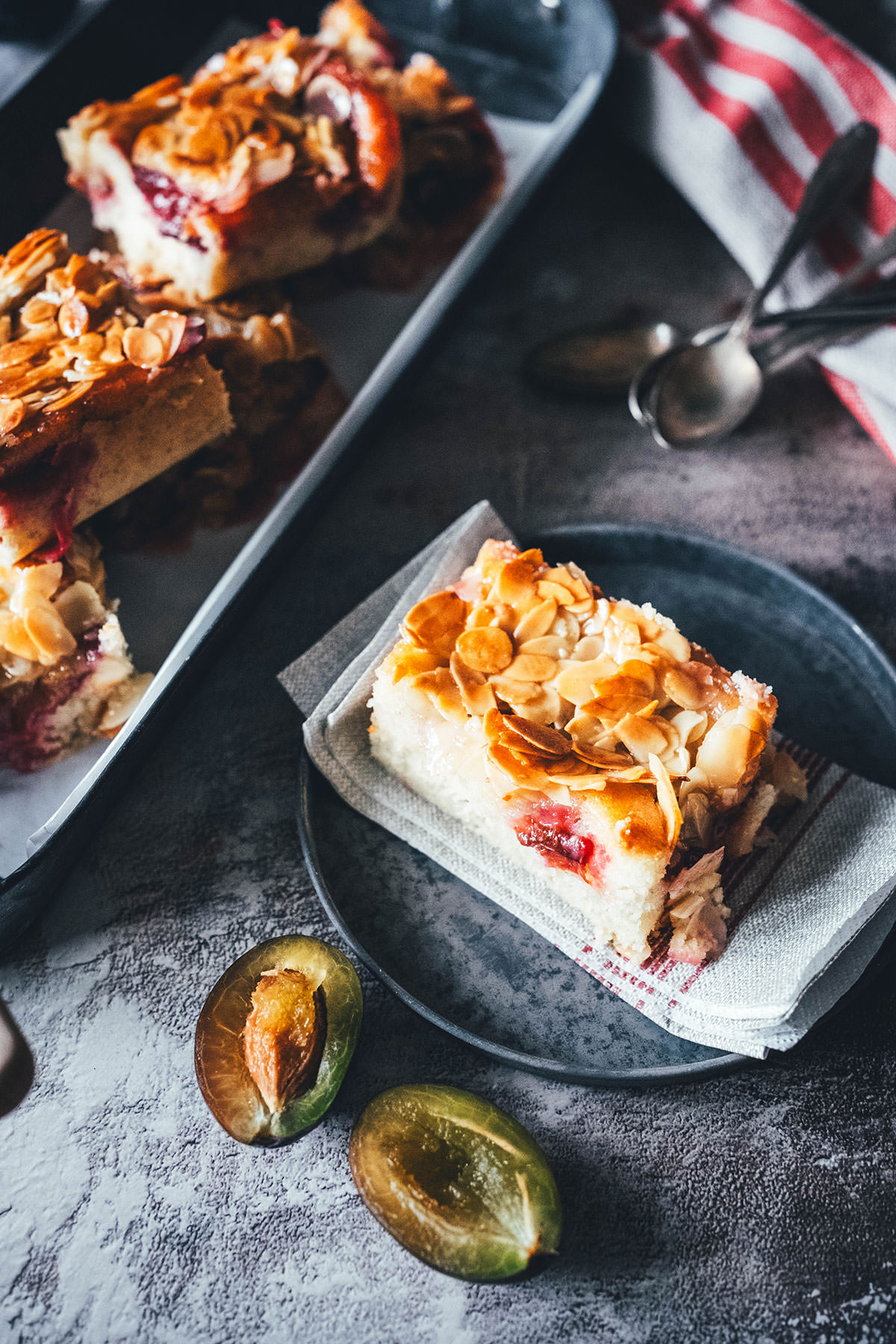 Rezept für blitzschnellen Zwetschgenkuchen. Sahne statt Butter im Teig, macht die Zubereitung ganz easy und sorgt für ein besonders luftiges und fluffiges Ergebnis. Getoppt wird der Pflaumenkuchen mit einem buttrigen und knusprigen Mandeltopping, wie man es von Bienenstich kennt. Ein wunderbarer Spätsommer- oder Herbstkuchen, der auch mit gefroreren oder eingemachten Zwetschgen funktioniert und eine super Alternative zu klassischem Zwetschgenkuchen! | moeyskitchen.com