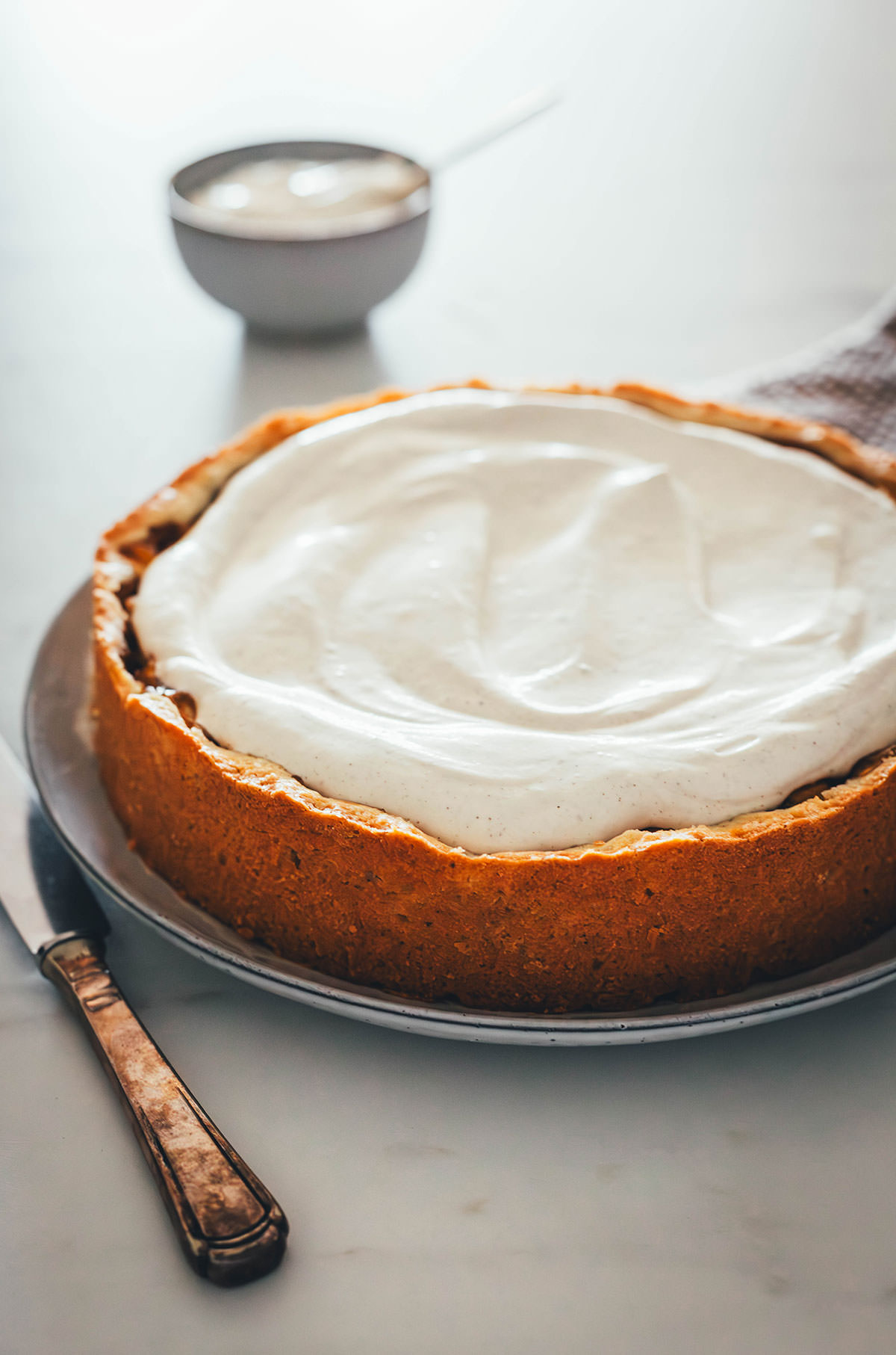 Rezept für Apfelkuchen mit knusprigem Mürbeteigboden und einer Füllung mit Äpfeln. Vanillepuddingpulver wird hier einfach mit Apfelsaft angerührt und mit Apfelstückchen gefüllt. Das ergibt die köstliche Füllung für diesen simplen Apfel-Pudding-Kuchen. Getoppt wird der Kuchen dann mit einer ganz lockeren Schmandcreme mit Vanille. | moeyskitchen.com