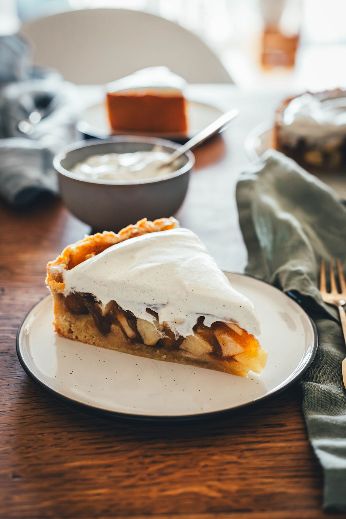 Rezept für Apfelkuchen mit knusprigem Mürbeteigboden und einer Füllung mit Äpfeln. Vanillepuddingpulver wird hier einfach mit Apfelsaft angerührt und mit Apfelstückchen gefüllt. Das ergibt die köstliche Füllung für diesen simplen Apfel-Pudding-Kuchen. Getoppt wird der Kuchen dann mit einer ganz lockeren Schmandcreme mit Vanille. | moeyskitchen.com