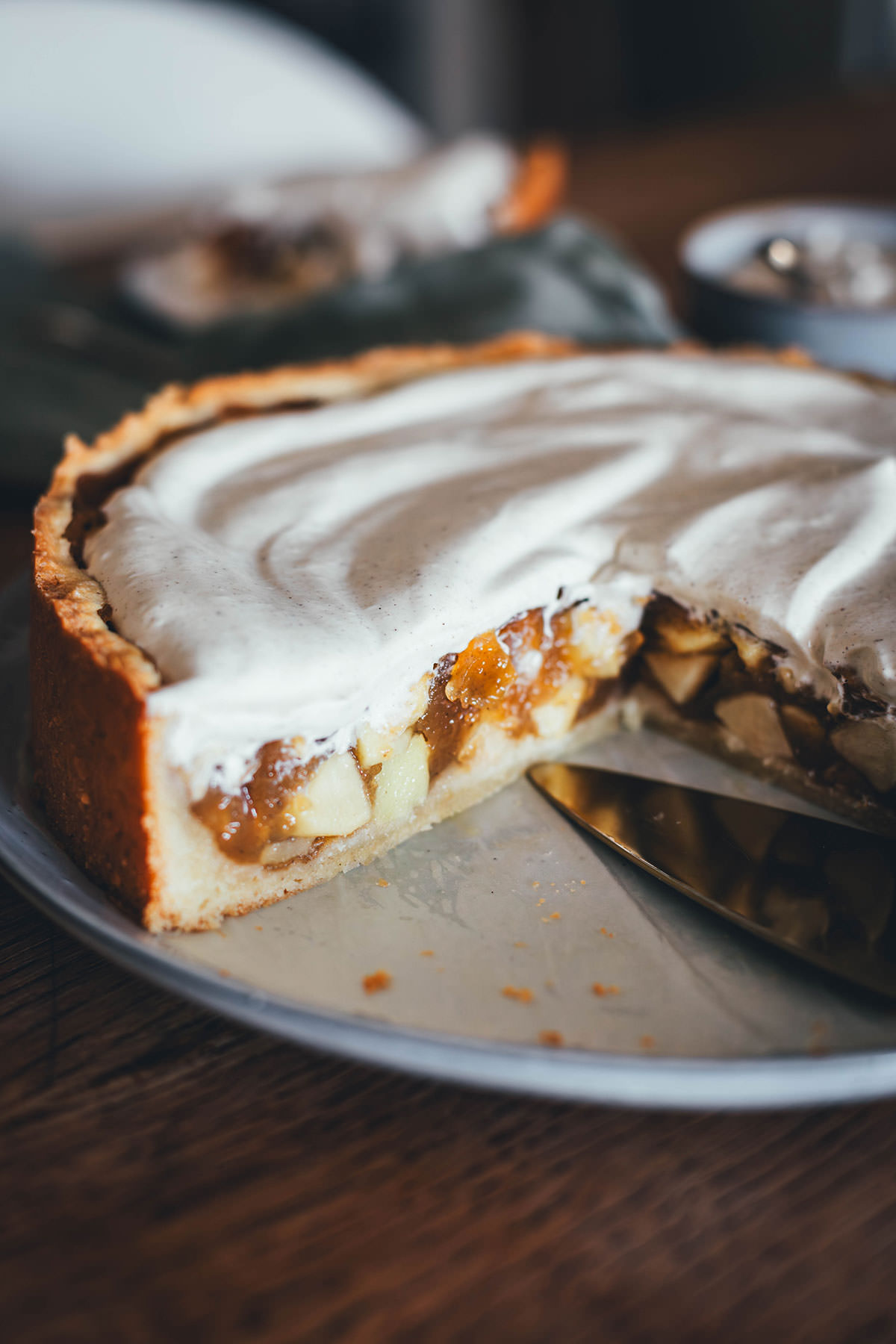 Rezept für Apfelkuchen mit knusprigem Mürbeteigboden und einer Füllung mit Äpfeln. Vanillepuddingpulver wird hier einfach mit Apfelsaft angerührt und mit Apfelstückchen gefüllt. Das ergibt die köstliche Füllung für diesen simplen Apfel-Pudding-Kuchen. Getoppt wird der Kuchen dann mit einer ganz lockeren Schmandcreme mit Vanille. | moeyskitchen.com