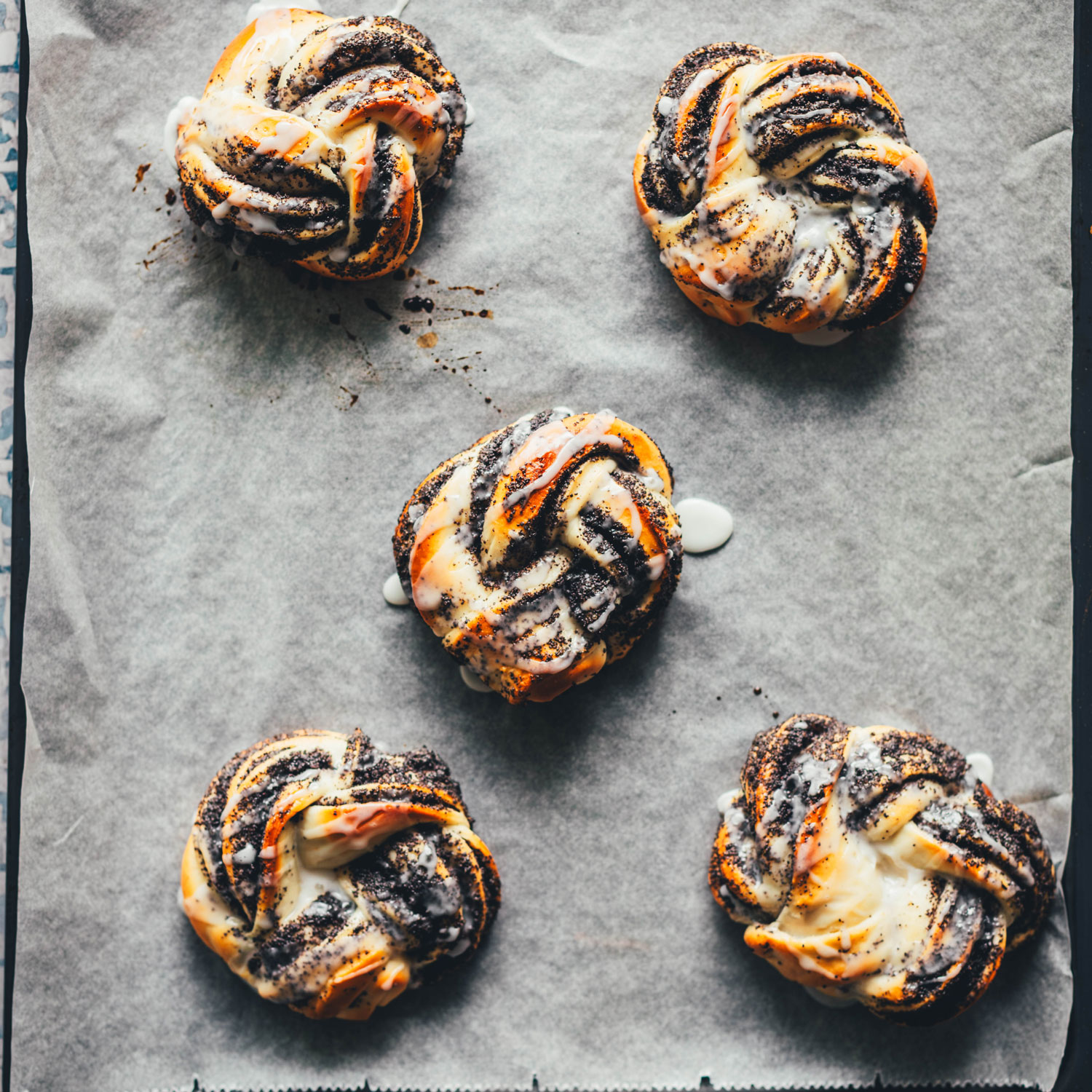 Topshot-Aufnahme von gebackenen und glasierten Mohnschnecken auf einem Backblech | moeyskitchen.com