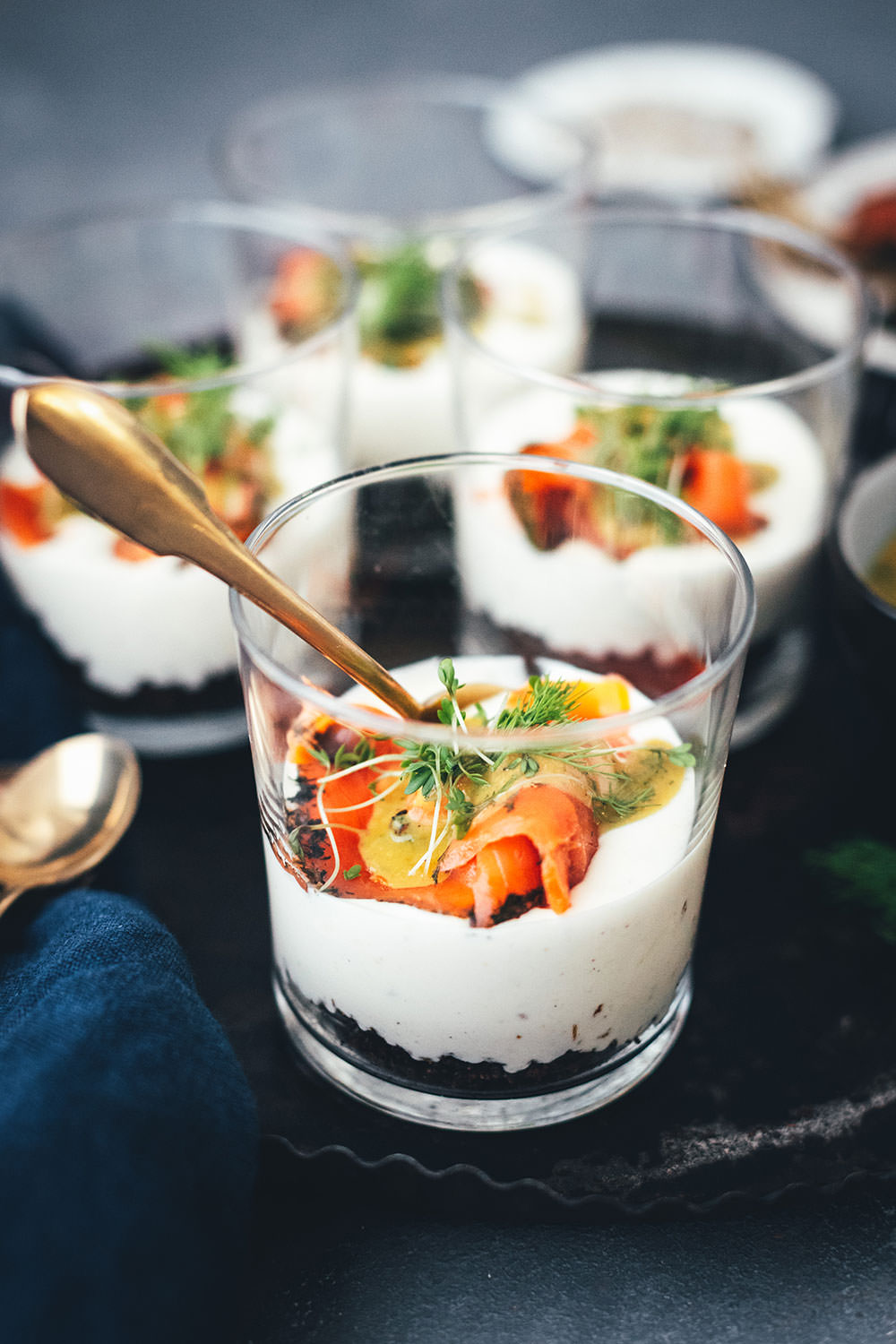 Rezept für Lachs-Trifle mit Honig-Senf-Sauce. Festliche Vorspeise für Brunch, Buffet oder Menü im Advent oder zu Weihnachten. In kleinen Gläsern serviert macht dieses Gericht richtig etwas her, ist aber wirklich unkompliziert zubereitet und unglaublich lecker. Meerrettich-Creme trifft hier auf Pumpernickel und Graved Lachs | moeyskitchen.com