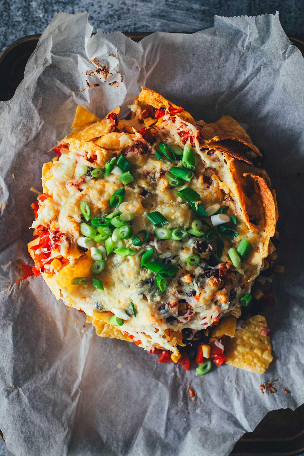 Loaded Nachos aus der Heißluftfritteuse sind eine blitzschnelle und unkomplizierte Idee für mit Käse und Toppings überbackene Tortilla Chips als Snack. Dafür werden alle Zutaten in den Airfryer geschichtet und zusammen gebacken. Anschließend kann man die Nachos mit Guacamole und Sour Cream servieren. | moeyskitchen.com