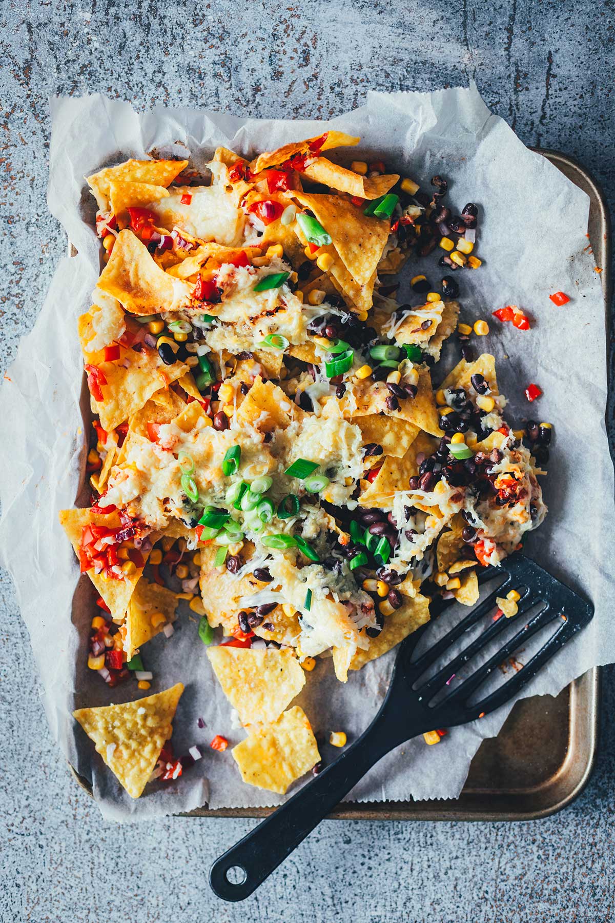 Loaded Nachos aus der Heißluftfritteuse sind eine blitzschnelle und unkomplizierte Idee für mit Käse und Toppings überbackene Tortilla Chips als Snack. Dafür werden alle Zutaten in den Airfryer geschichtet und zusammen gebacken. Anschließend kann man die Nachos mit Guacamole und Sour Cream servieren. | moeyskitchen.com