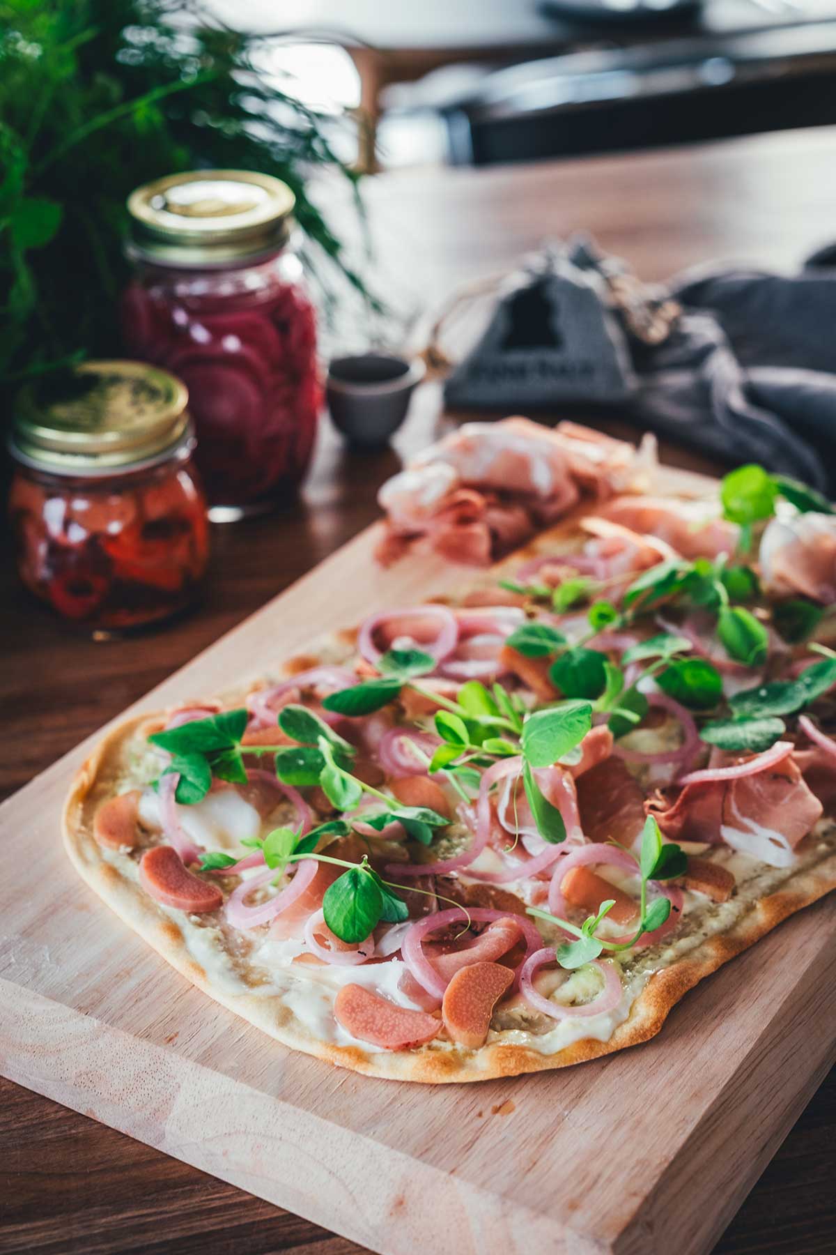 Mein Rezept für einen knusprigen Flammkuchen ohne Hefeteig. Belegt mit Schinken und eingelegtem Gemüse. | moeyskitchen.com