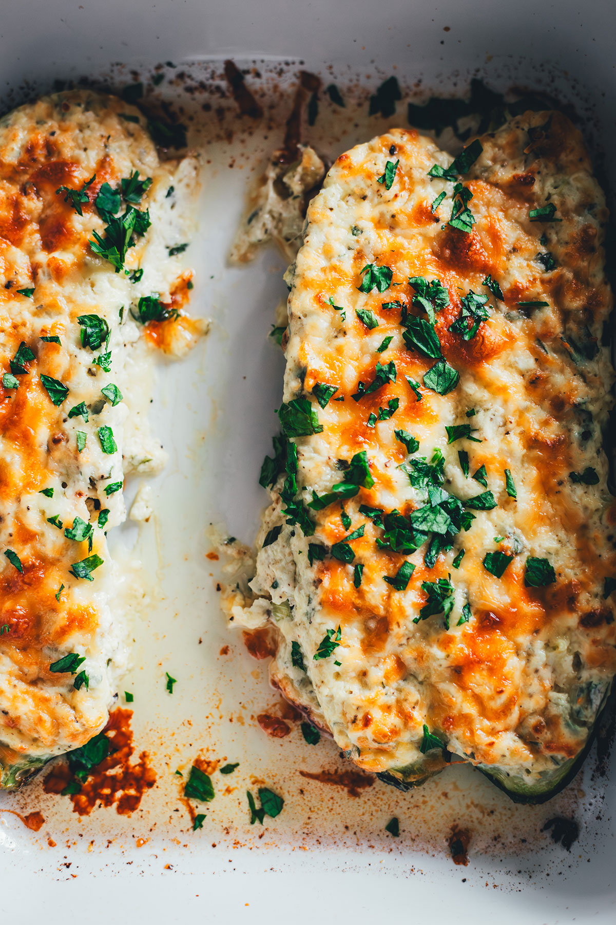 Mit Ricotta-Creme gefüllte und mit Mozzarella und Parmesan überbackene Zucchini! Geht sie wieder los, die Zucchinischwemme? Dann hab ich hier ein neues, unkompliziertes und vor allem super schnelles Rezept für euch: vegetarisch gefüllte Zucchini! | moeyskitchen.com