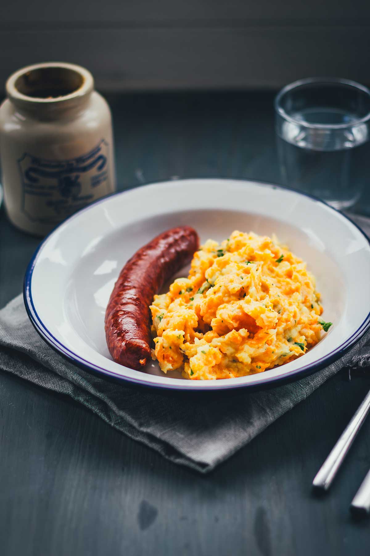 Rezept für einfache und deftige Hausmannskost: Kartoffel-Möhren-Stampf einfach selbst zubereitet. Serviert mit würziger Mettwurst ist das das perfekte Abendessen in der kalten Jahreszeit und genau das richtige für den Herbst. | moeyskitchen.com