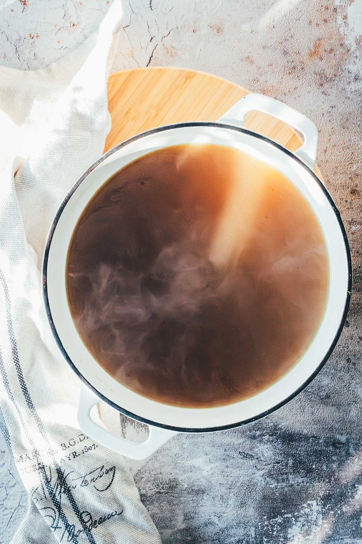 Frisch gekochte, selbst gemachte Gemüsebrühe in einem gusseisernen Topf | moeyskitchen.com