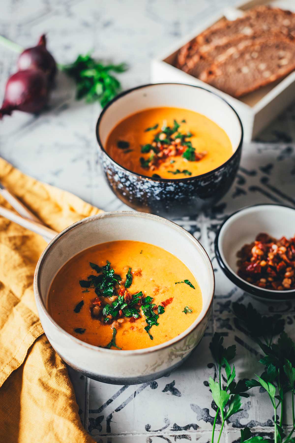 Tomaten-Linsen-Suppe mit Schmand, serviert mit frischen Kräutern und gehackten getrockneten Tomaten. | moeyskitchen.com