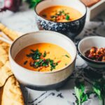 Tomaten-Linsen-Suppe mit Schmand, serviert mit frischen Kräutern und gehackten getrockneten Tomaten. | moeyskitchen.com