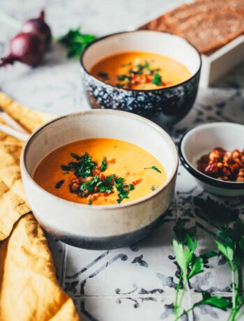 Tomaten-Linsen-Suppe mit Schmand, serviert mit frischen Kräutern und gehackten getrockneten Tomaten. | moeyskitchen.com
