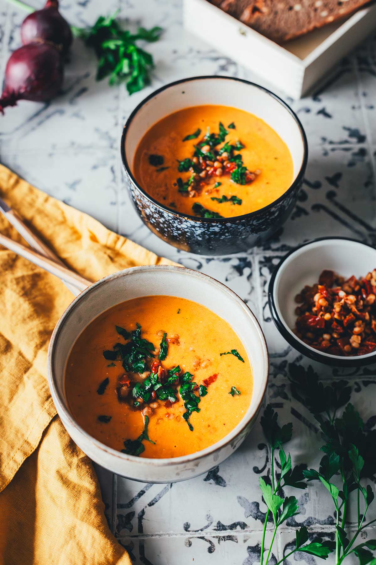 Tomaten-Linsen-Suppe mit Schmand, serviert mit frischen Kräutern und gehackten getrockneten Tomaten. | moeyskitchen.com