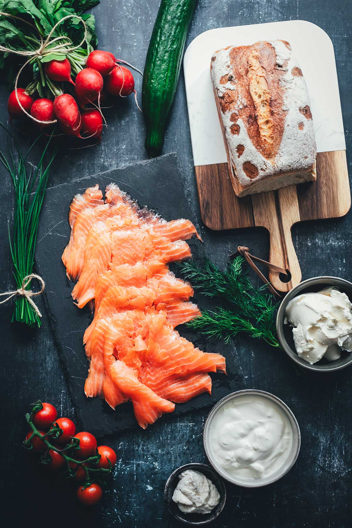 Klassische Smörgåstårta Zutaten als Topshot: Alle Zutaten für die Sandwichtorte von Kastenweißbrot über Graved Lachs bis hin zu Frischkäse, Meerretich, Dill und Schnittlauch