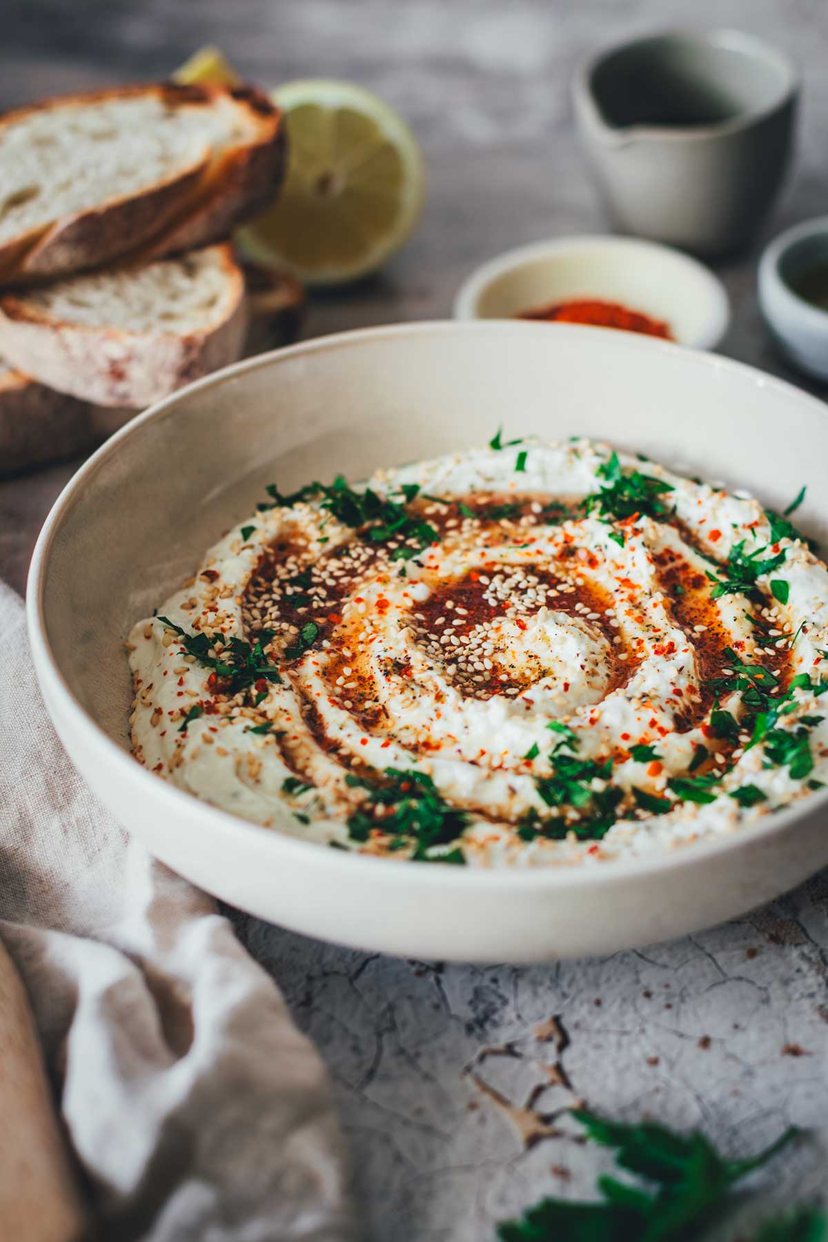 Whipped Feta mit Hot Honey ist ein orientalisch angehauchter Dip und perfekt für den Sommer – mit Feta, Frischkäse und Joghurt, dazu Honig mit Chili. Serviert mit Sesam, Pistazienkernen und Petersilie. | moeyskitchen.com