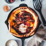 Dutch Baby Rezept für fluffigen Ofenpfannkuchen. Außen knusprig, innen weich, wie ein großer Pancake. Mit Beeren, Ahornsirup und Mandelmus. | moeyskitchen.com