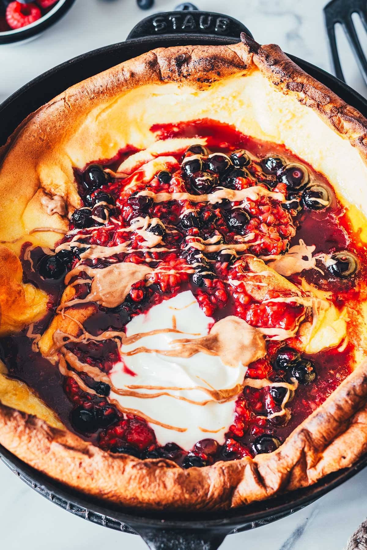 Dutch Baby Rezept für fluffigen Ofenpfannkuchen. Außen knusprig, innen weich, wie ein großer Pancake. Mit Beeren, Ahornsirup und Mandelmus. | moeyskitchen.com