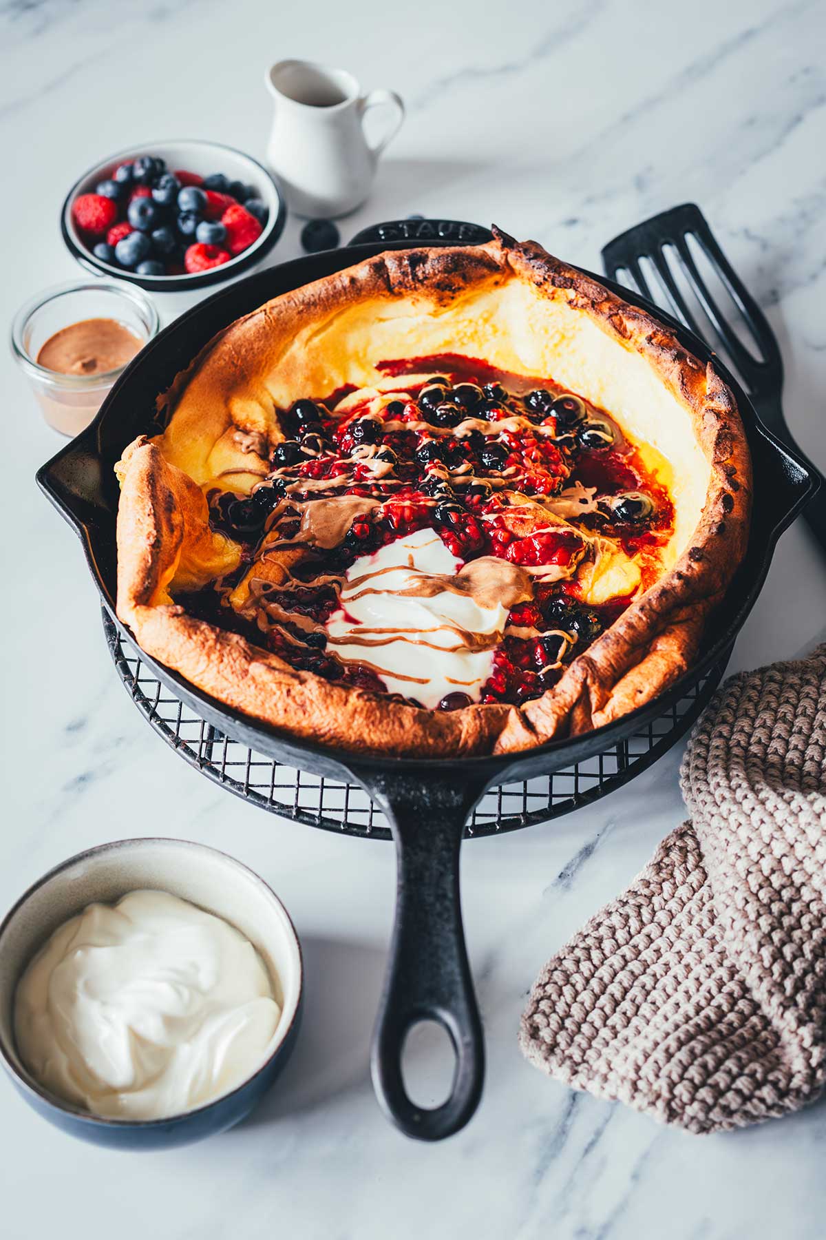 Dutch Baby Rezept für fluffigen Ofenpfannkuchen. Außen knusprig, innen weich, wie ein großer Pancake. Mit Beeren, Ahornsirup und Mandelmus. | moeyskitchen.com