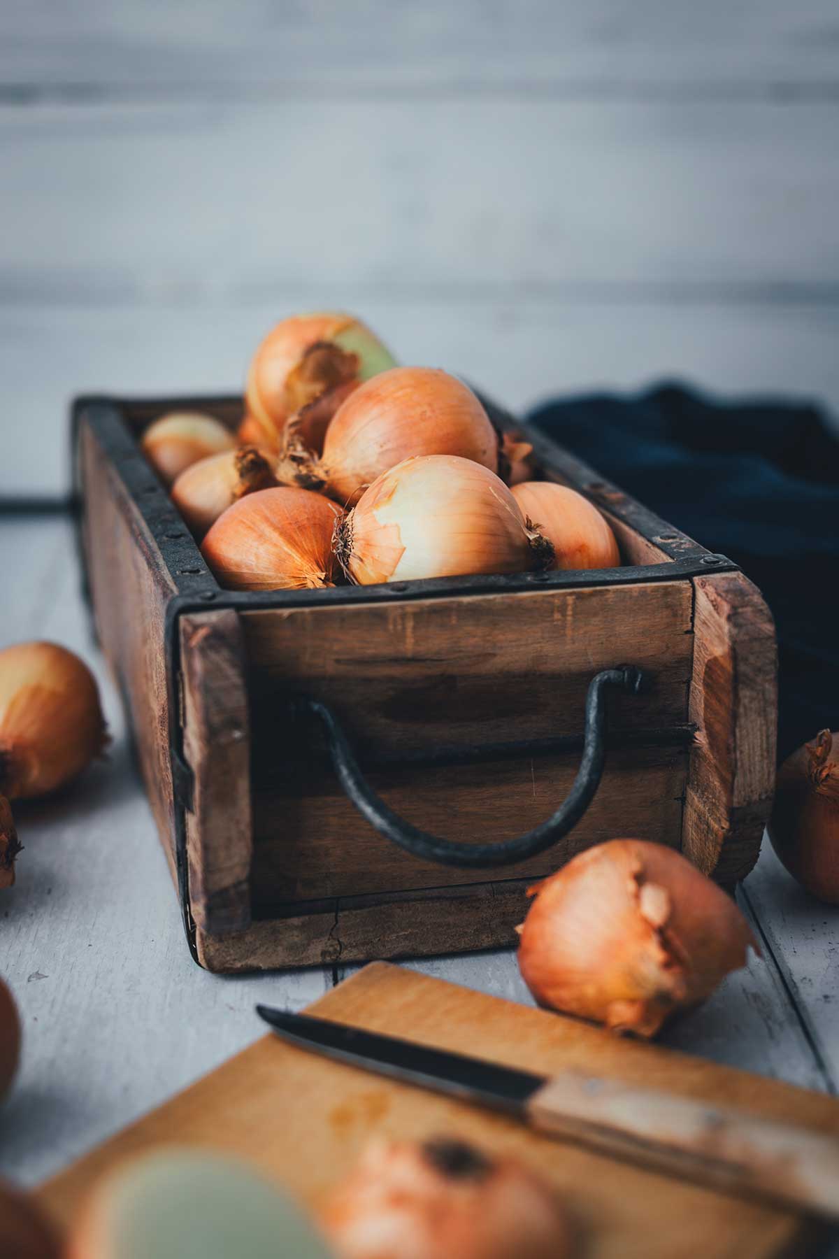 Frische gelbe Zwiebeln in einer rustikalen Holzkiste – Zutat für Zwiebeltarte | moeyskitchen.com