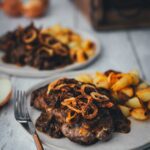 Zwiebelrostbraten mit Sauce, Röstzwiebeln und Bratkartoffeln auf zwei Tellern serviert | moeyskitchen.com