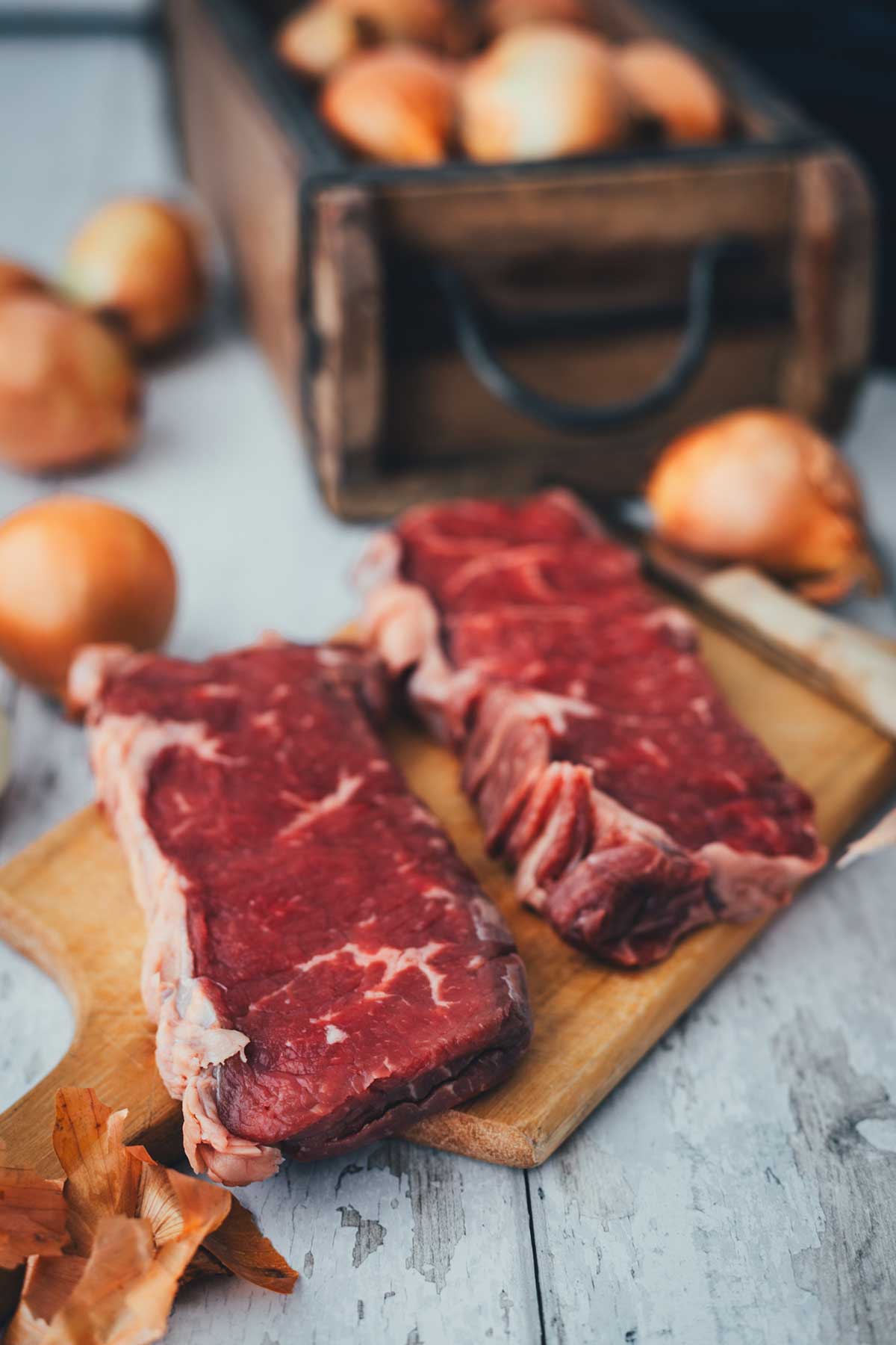 Rohe Rumpsteaks mit Fettrand auf Holzbrett – Zubereitung für Zwiebelrostbraten | moeyskitchen.com