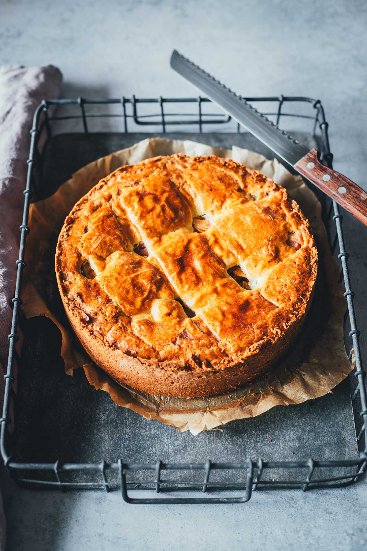 goldbraun gebackener Apfelkuchen, auf einem Stück Backpapier auf einem Tablett serviert | moeyskitchen.com