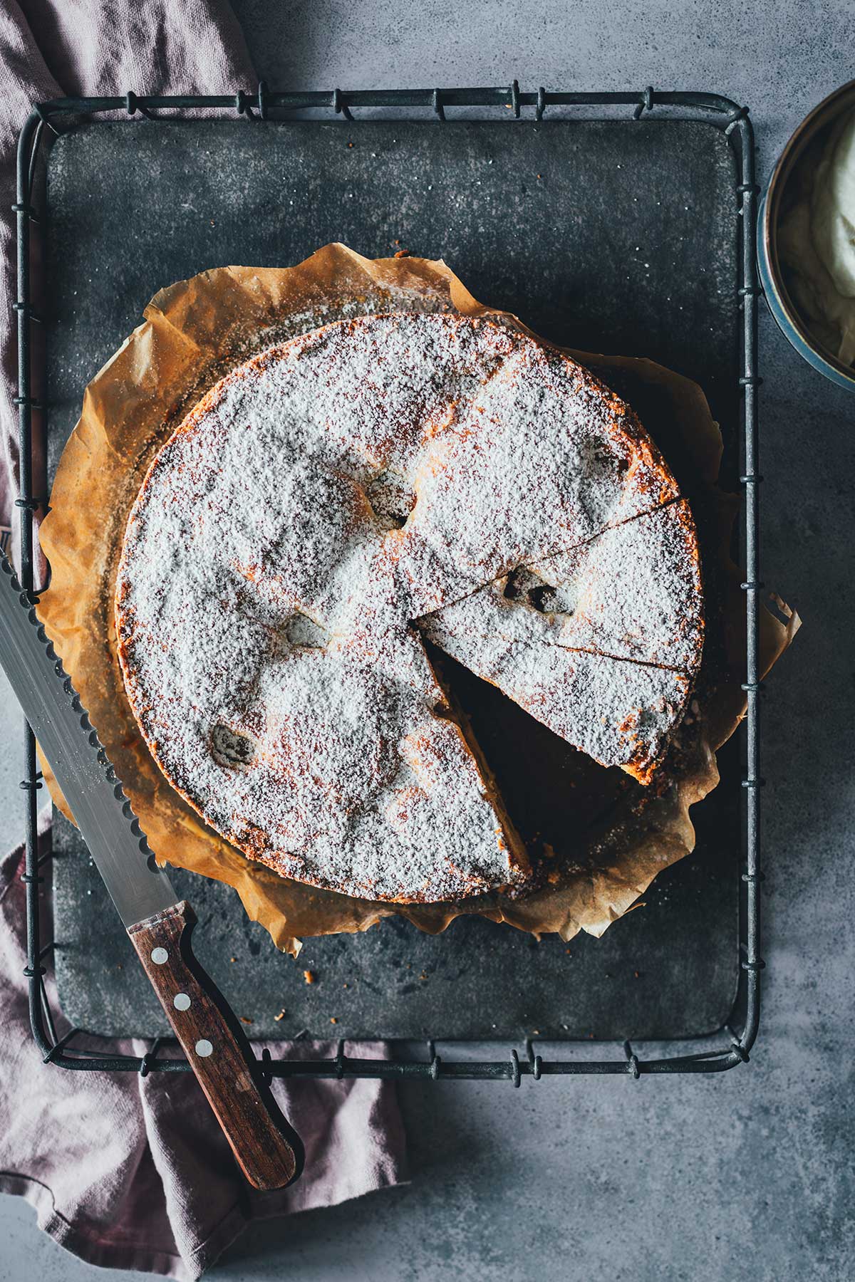 Topshot der angeschnittenen und mit Puderzucker bestreuten Appeltaart auf einem Tablett | moeyskitchen.com
